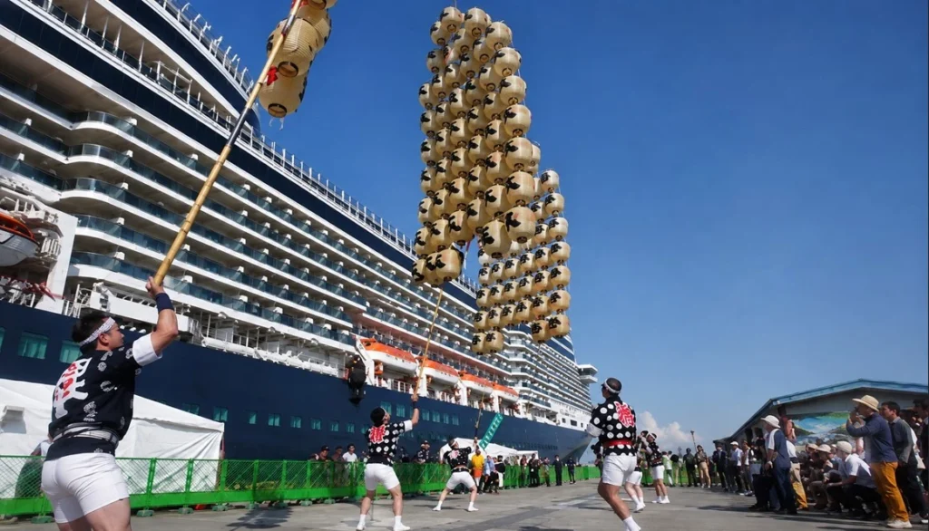 秋田港に寄港したクルーズ船の前で披露される竿燈演技