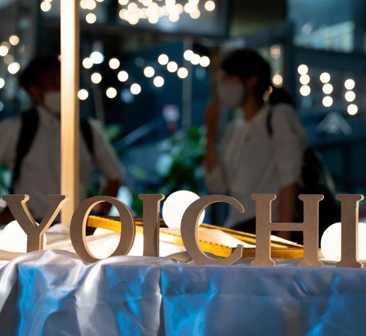 秋田市で開催される亀の町夜市のYOICHIサインと会場のライト