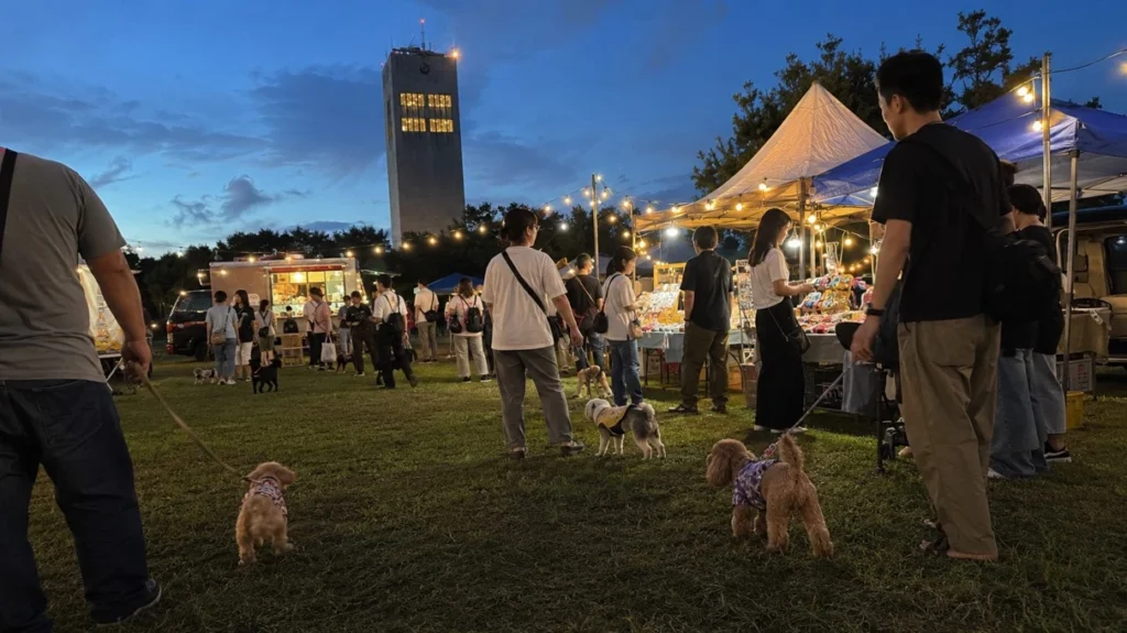 天王グリーンランドの物販ブースやキッチンカーを愛犬連れで巡る来場者のイメージ