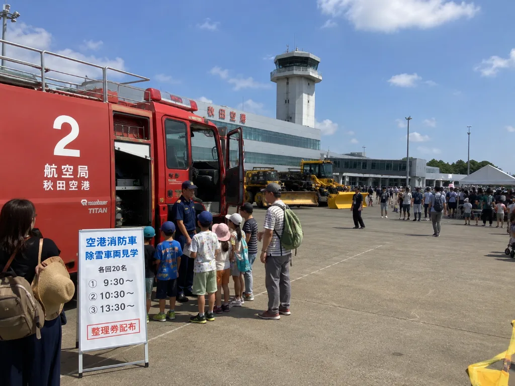 秋田空港の消防車前に並ぶ見学参加者