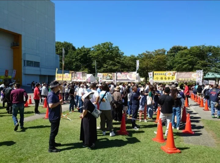 秋田ふるさと村の屋外イベント会場に集まる来場者