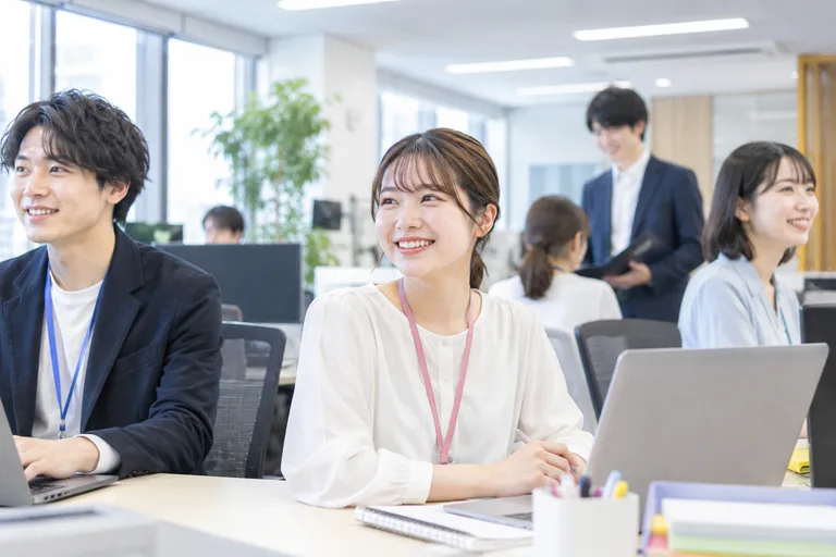 パソコンを使って働く人たちがいるオフィス