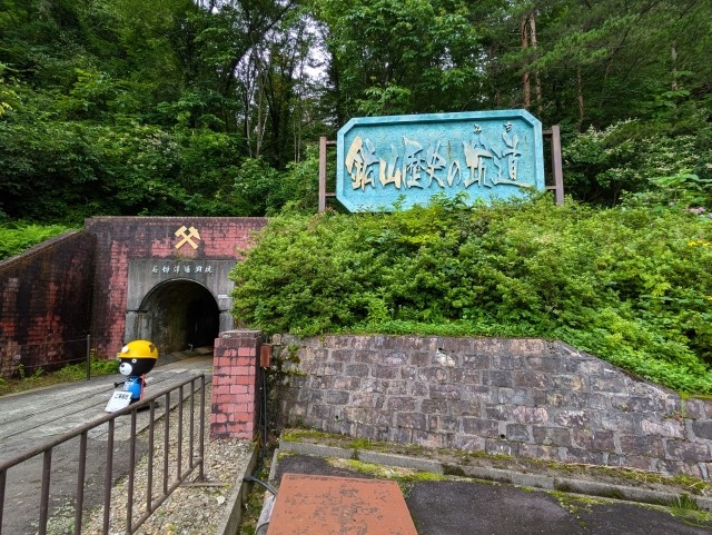 「鉱山歴史の道」の看板がある尾去沢鉱山の坑道入口