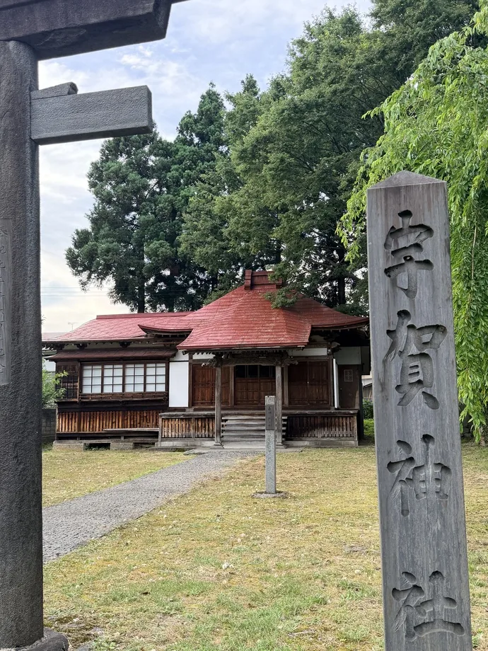 鳥居越しに見える木造の社殿と矢島の境内