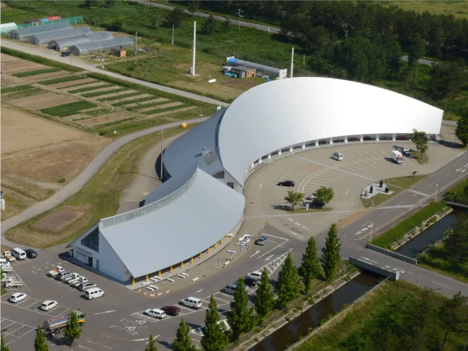田畑に囲まれた大潟村干拓博物館を上空から見た外観